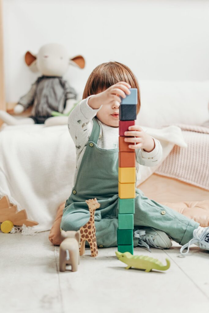 kind speelt met hout speelgoed